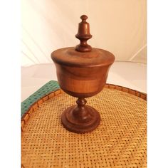 a wooden bowl sitting on top of a wicker tablecloth covered tray with a green mat underneath it