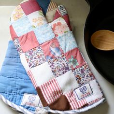 an oven mitt sitting on top of a counter next to a pan and spatula