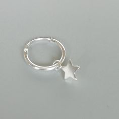 A PAIR of sterling silver hoops. Comes with a detachable tiny and delicate star charm. The charm is multipurpose and can be used with a neck or bracelet chain too. Dimension: Hoop- 12 x 1.5 mm Charm- 5 x 5 mm Drop length- 18 mm Price listed is for a PAIR of hoops. These earrings are made of 925 hypoallergenic sterling silver and comes with a 925 stamp. Can be packaged in a gift box. I can include a personal message from you if needed You are welcome to contact me at... bhavnakwintra1956@gmail.co Minimalist Silver Star Hoop Earrings, Sterling Silver Star Cartilage Earrings With Star Charm, Sterling Silver Star Charm Cartilage Earrings, Silver Star Huggie Earrings Minimalist Style, Minimalist Silver Star Cartilage Earrings, Minimalist Silver Star Huggie Earrings, Silver Star-shaped Minimalist Huggie Earrings, Silver Star-shaped Hoop Earrings For Everyday, Sterling Silver Cartilage Earrings With Star Charm