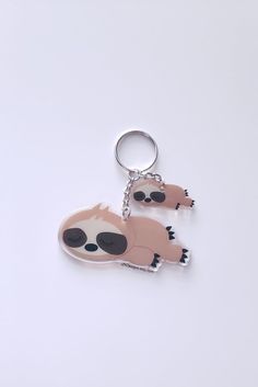 two slotty keychains with sunglasses on them sitting next to each other in front of a white background