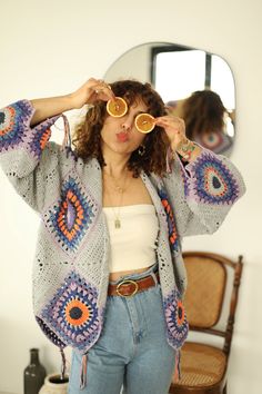 a woman standing in front of a mirror holding up her glasses