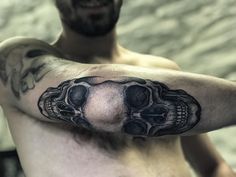 a man with a skull tattoo on his arm