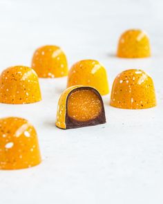 several pieces of candy sitting on top of a white table covered in gold flakes