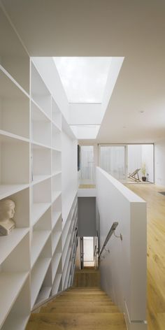 an empty room with white shelves and wooden flooring is seen from the top level