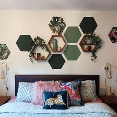 a bedroom with hexagonal wall decorations above the bed and pillows on the headboard