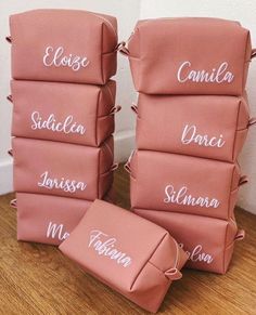 four pink bags with names on them sitting on the floor