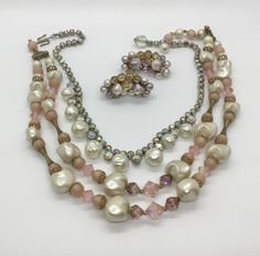 Vintage lot of 3, sold together only. 2 bead necklaces from the 50s and one pair of clip earrings. First necklace is a beautiful pink and dusty pink purple two-strand necklace with aurora borealis pink and textured creamy satin white faux pearls. Hook closure. 15-16 inches. Second necklace is a sparkly aurora borealis rhinestone and dimpled faux pearl necklace. About 15 inches. Clip earrings measure 1.5 inches long, made of elegant grayish purplish faux pearls and shimmering aurora borealis. Wea Vintage Pink Single Strand Jewelry, Vintage Pink Beaded Jewelry, Pink Vintage Beaded Jewelry, Vintage Pink Beaded Necklaces For Jewelry Making, Vintage Single Strand Jewelry For Party, Pink Costume Jewelry Necklace For Evening, Pink Costume Jewelry For Evening, Evening Pink Costume Jewelry, Pink Vintage Jewelry For Vintage Events