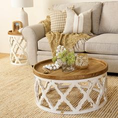 a living room with a couch, coffee table and two vases on the floor