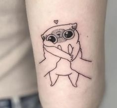 a small tattoo with an owl holding a baby on it's arm, in the shape of a heart