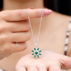 Product Details The lab created emerald flower cocktail pendant with Diamond is a wearable oasis, capturing the beauty and magic of nature in a stunning piece of jewelry. The pendant features a 5 MM emerald center stone flower, its petals adorned with sparkling Diamond and pear-shaped emerald stones. As you move, the pendant comes alive, its emerald petals shimmering and its Diamond stones twinkling like stars. This pendant is a perfect gift for a woman who loves the beauty of nature and the mag Elegant May Birthstone Necklace In Flower Shape, Elegant Flower Shaped Necklace With May Birthstone, Elegant May Birthstone Necklace With Flower Shape, Elegant Flower-shaped Necklace With May Birthstone, Elegant Flower-shaped May Birthstone Necklace, Green Flower Pendant Jewelry For Anniversary, Green Flower Pendant Fine Jewelry, Green Flower-shaped Jewelry For Anniversary, Green Flower Shaped Anniversary Jewelry