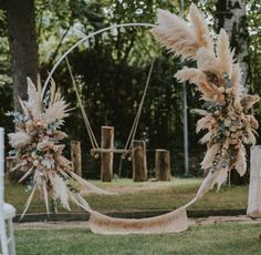 an outdoor ceremony setup with pamodia and feathers