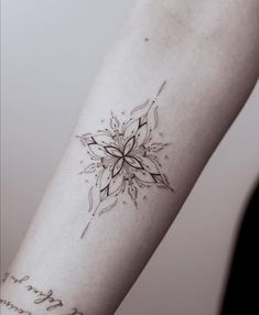 a woman's arm with a flower tattoo on the left side of her arm