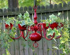 a red chandelier hanging from a wooden fence