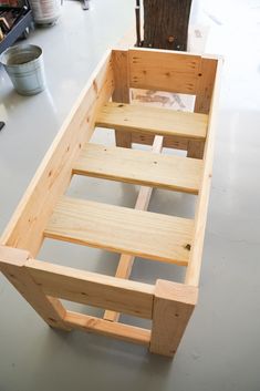 a bench made out of wood sitting on top of a table next to a tree