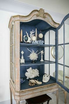 an old china cabinet with glass doors and decorative items on it's front shelf