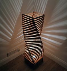 a wooden sculpture sitting on top of a hard wood floor next to a white wall