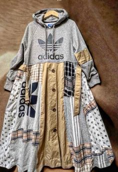 an adidas jacket is hanging on a wall next to a brown and white blanket