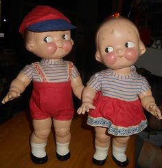 two dolls are standing next to each other