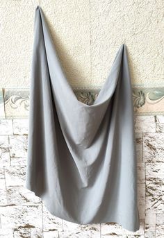 a gray blanket hanging up against a wall