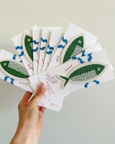 a person holding up some cards with fish on them