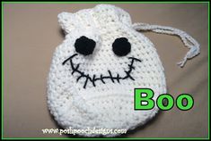 a crocheted white bag with black eyes and mouth on the front, which says boo