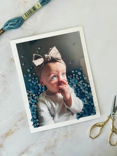 a photo of a baby with a bow on her head and scissors next to it