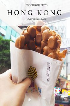 a person holding a paper bag full of dog treats with the words, foodies guide to hong kong