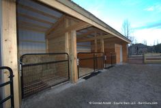 a horse barn with stalls and fences around it