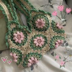 a crocheted purse sitting on top of a bed next to a white pillow