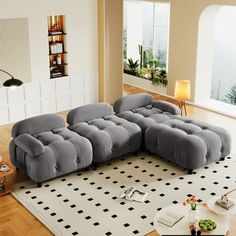 a large gray couch sitting on top of a white rug