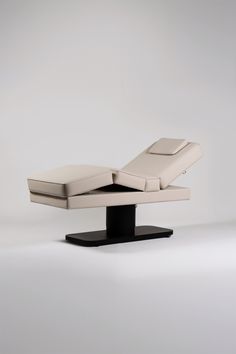 an image of a modern reclining chair with the back rest folded down on it's base