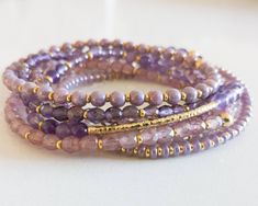 "Monochromatic bracelet stacks, made up of high-quality czech glass beads and semi-precious gemstones! This purple stack contains a semi-precious amethyst bracelet. Purchase an individual bracelet, or choose \"Entire Stack\" from the drop-down to receive one of each. The bracelets have been designed to look great on their own, and they stack beautifully with any of the bracelets in our shop!  All the bracelets in the stack are a dainty 4mm size-- the faceted glass beads hit the light and create Purple Bracelets, Bracelets Purple, Neutral Bracelets, Amethyst Crystal Bracelet, Wire Jewerly, Purple Beaded Bracelets, White Beads Bracelet, Purple Accessories, Bracelet Stacks