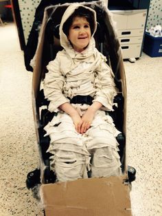 a young boy sitting in a cardboard cart