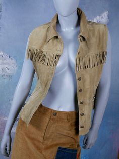 This tan leather vest has a wing collar, and closes in the front with seven bronze buttons. The straight-front Western style cowboys and Indians vest has a row of 2.5-inch (6.35cm) fringe across the bust line, and features corset-style lacing on each side. Bust = 38 inches (96.52cm) Vest Length = 21.5 inches (54.61cm) Size: 10 US, 14 UK Material: Genuine Leather --- CONDITION --- This tan leather vest is vintage, but is in Excellent condition, and is clean, soft, and supple. There are no tears, Mad Men Dresses, Formal Cocktail Party, Wing Collar, Cowboys And Indians, A Wing, European Vintage, Pig Skin, Leather Vest, Plaid Blazer