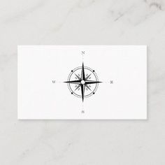 a white business card with a black compass design on the front and bottom corner,