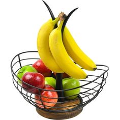 a wire basket filled with apples, bananas and other fruit sitting on top of each other