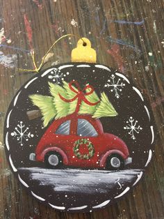 a painted ornament with a car carrying a christmas tree