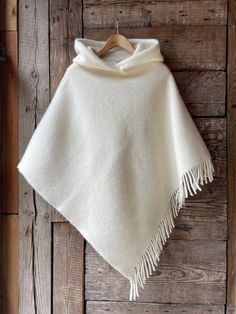 Cream white hooded lambswool poncho cape with fringes Ladies poncho Pure wool hooded ladies poncho Milk White pure wool blanket poncho cape One size fits fashionably for most everyone, short or tall, big or small. This piece is versatile for both Men's & Women's outdoor fashion, and can be used insider in cooler winter weather to keep warm while reading on the couch. CARE: Hand-wash and hang to dry, light iron if needed, or dry clean. MEASURES: Length at the front of the neckline to the bottom is ~90 cm/35 inches, the shoulder length is ~55cm/22 inches; COMPOSITION: 100% lambswool If you like this, bookmark & browse my shop for other items! Save, Share, Pin or Post! Browse the Shop: https://www.etsy.com/shop/Lovetosleep Thank You for visiting! Have a lovely day. Anita from Lovetosleep White Blanket Coat, Luxury Cream Poncho For Winter, White Sweater Poncho, Cheap White Casual Poncho, Cheap Fall Poncho Cape, Luxury Oversized White Poncho, Poncho Coat Outfit, Poncho Outfit Winter, Womens Outdoor Fashion