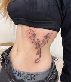 a woman with a dragon tattoo on her stomach