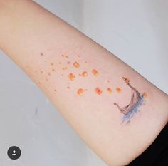 a person with a small tattoo on their arm that has orange dots all over it