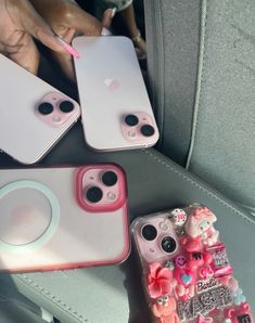 three cell phones sitting on top of a car seat next to plates and cupcakes