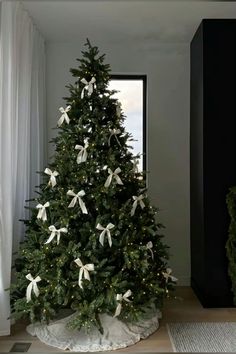 a decorated christmas tree with white bows