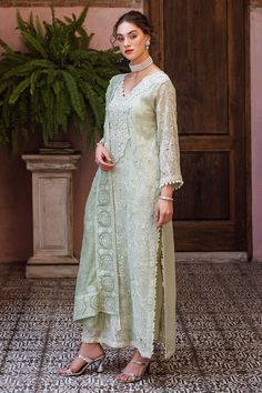 Dhara, a luxurious ensemble featuring a chikankari embroidered shirt adorned with a milky lace and pearl accents. The look is complete with a dupatta, featuring chikankari embroidery, light sequins, and pearl tassels thus adding a touch of elegance. This is a 3 pc outfit. Semi-stitched Traditional Wear With Lace Work For Eid, Elegant Naqshi Dupatta For Reception, Lawn Suit With Chikankari Embroidery For Reception, White Naqshi Sharara For Reception, Naqshi Embroidered Lawn Suit For Reception, Unstitched Chikankari Lawn Suit For Receptions, Elegant Semi-stitched Naqshi Palazzo Set, Elegant Semi-stitched Palazzo Set With Naqshi, Eid Lawn Suit With Chikankari Embroidery For Reception