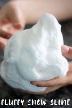 a person holding a white ball of fluffy snow slime in their hands