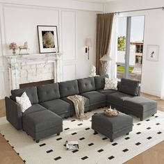 a living room with a sectional couch and ottoman in front of a fire place on the wall