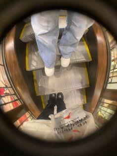 the person is standing on an escalator with their feet up