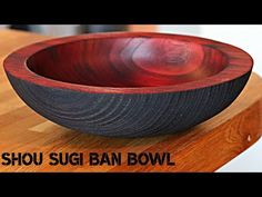 a bowl sitting on top of a wooden table next to the words shou sugi ban bowl