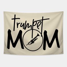 a white wall hanging with the words trumpet mom and a trombone in black on it