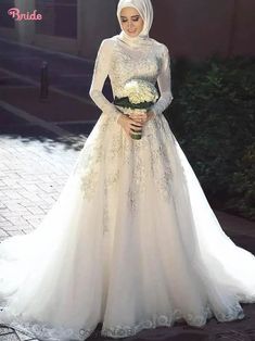 a woman in a wedding dress standing on a sidewalk