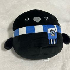 a stuffed animal with a blue and white striped hat on it's head is laying down